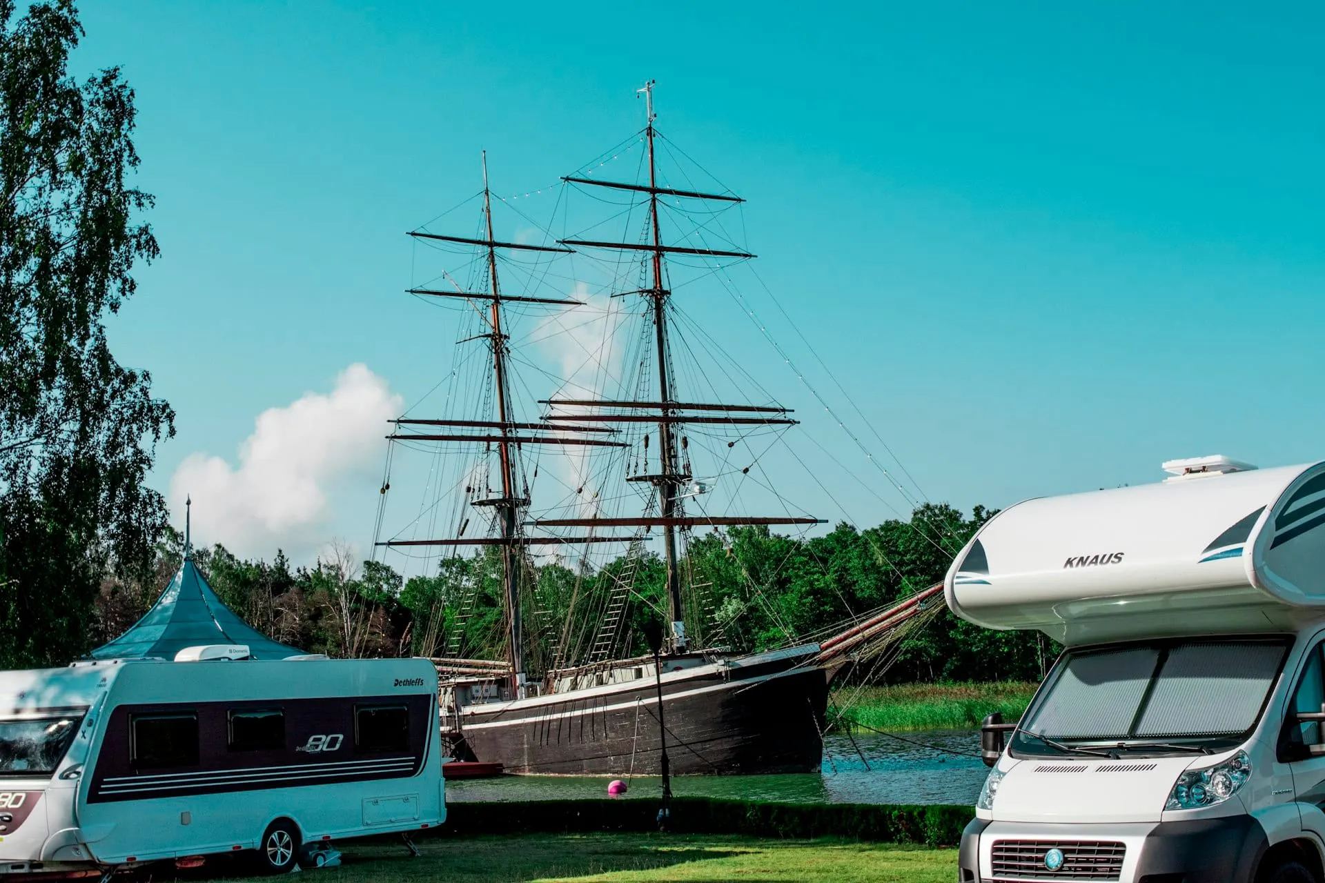 Des vans aménagés garés sur les emplacements en herbe d'un camping européen