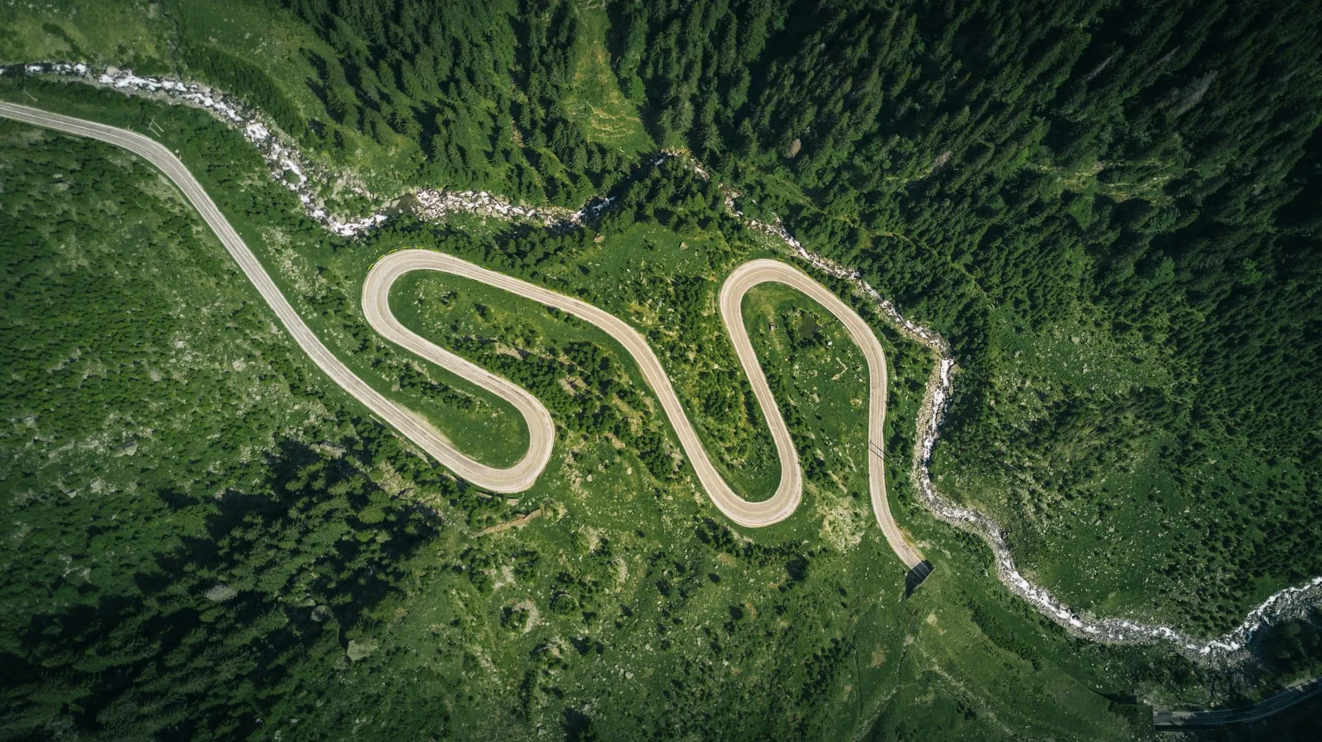 Un van in un tornante in cima a un passo alpino nell'ora dorata