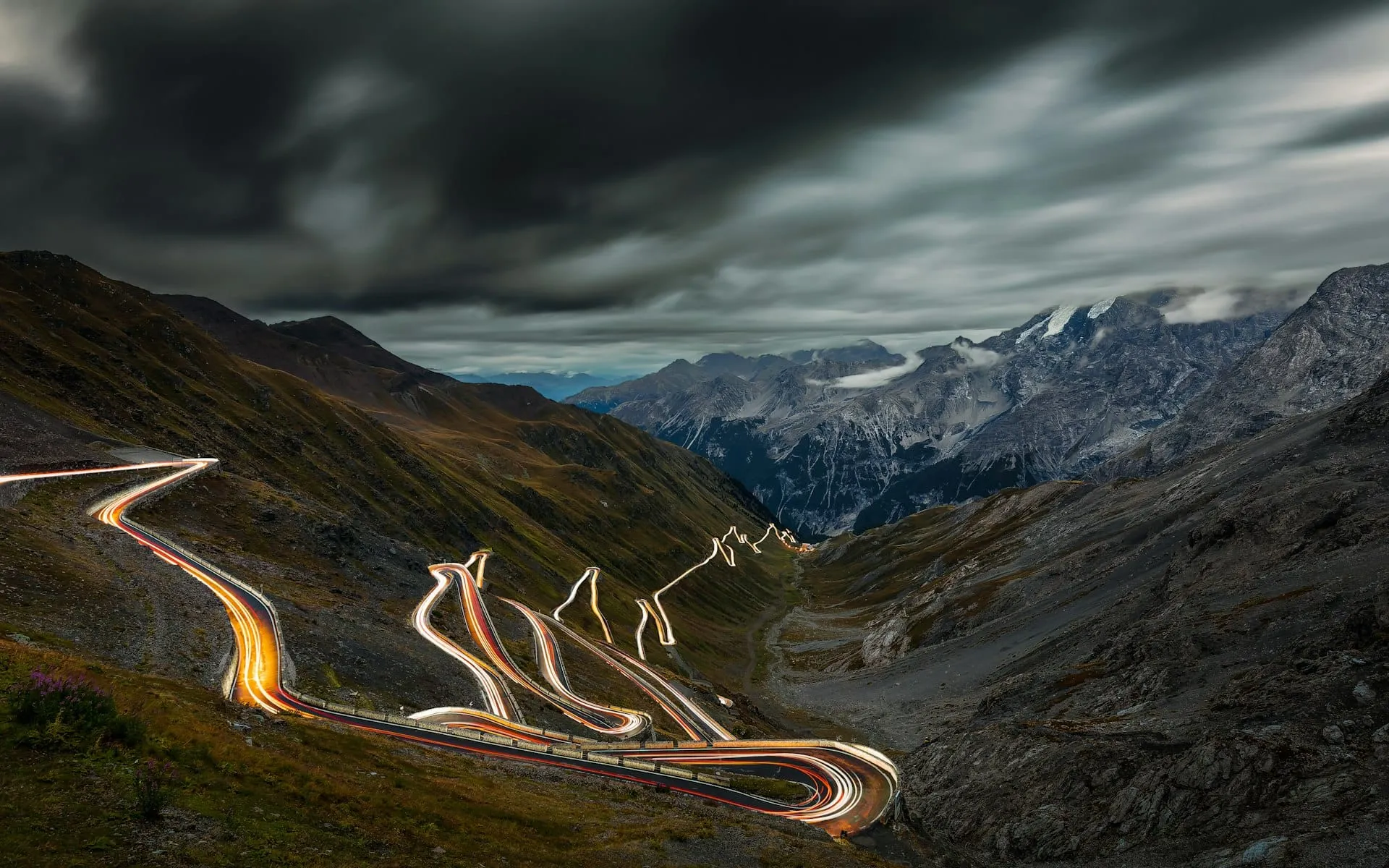 Lacets d'une route de col des Dolomites sous des tours de roche claire