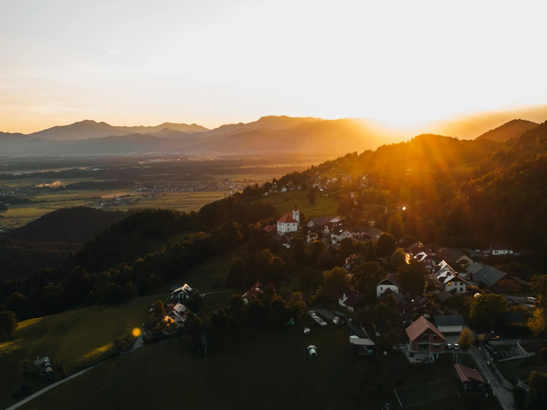 Un van aménagé garé sur un bas-côté herbeux en pleine campagne au coucher du soleil
