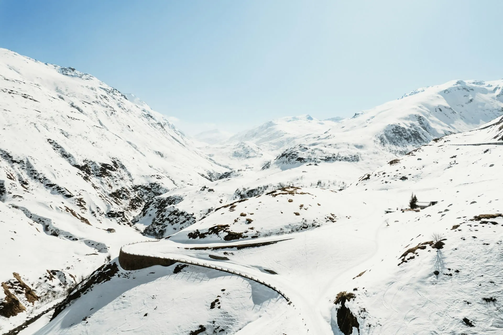 Un solo carril despejado entre altos muros de nieve en un valle de montaña